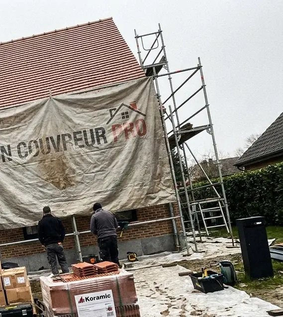Échafaudage monté contre la façade, bâche Mon Couvreur Pro tendue devant la maison
